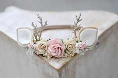 the headpiece is decorated with flowers and antlers on it's sides,