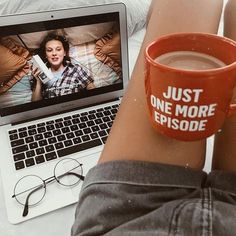 a woman is sitting in front of her laptop with a cup of coffee next to her