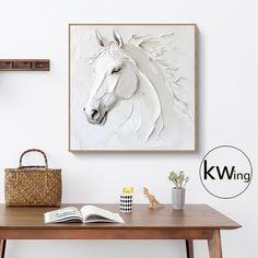 a white horse is on the wall next to a table with a book and purse