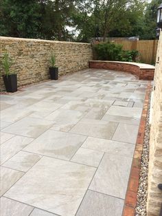 an outdoor patio with stone walls and planters