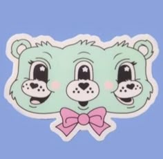 a green sticker with a pink bow on it's head and two eyes