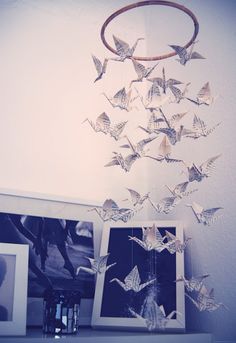 a group of framed pictures sitting on top of a table next to a vase with flowers in it