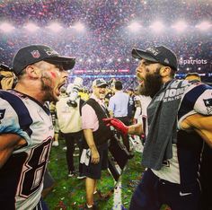 two football players standing next to each other on a field with confetti all over them