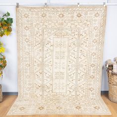 an old rug is hanging on the wall next to a basket with flowers in it