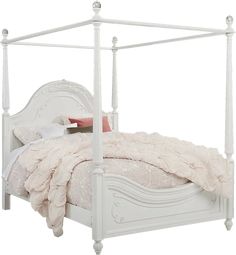 a white bed with four posts and pillows on it's headboard, in front of a white background