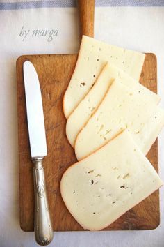 slices of cheese on a cutting board next to a knife