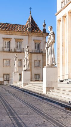 statues in front of an old building on a sunny day