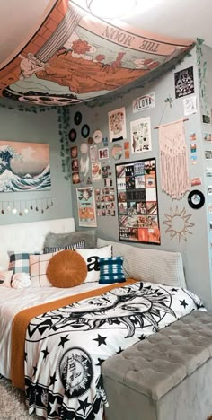 a bed room with a neatly made bed and lots of pictures on the wall above it