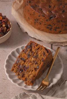 a piece of cake sitting on top of a white plate next to a bowl of beans