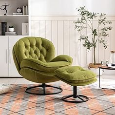 a green chair and ottoman in a living room with white walls, orange rugs and a potted plant