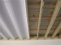 an unfinished ceiling with wood planks and white paint