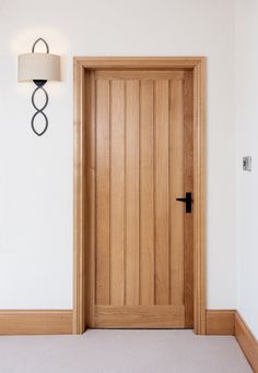 an empty room with a wooden door and lamp