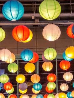 many colorful lanterns are hanging from the ceiling