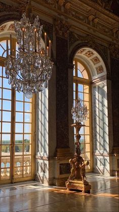 a chandelier in an ornate room with large windows