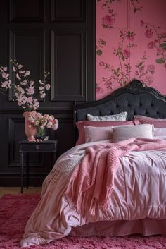 a bed with pink sheets and pillows in front of a floral wallpapered room