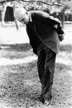 an old black and white photo of a man bending over