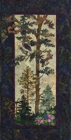 a quilted wall hanging with trees and flowers