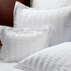 three white pillows sitting on top of a bed