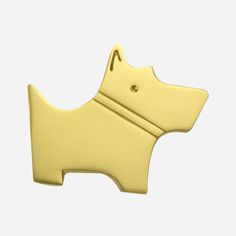 a yellow dog shaped brooch on a white background