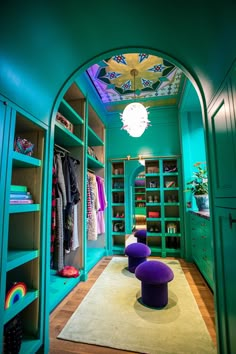 a room with blue walls and green closets filled with colorful items, including purple stools