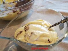 a glass bowl filled with ice cream next to another bowl full of desserts on a table