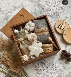 a wooden box filled with different items on top of a white table covered in snowflakes