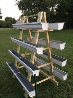 a set of benches sitting on top of a lush green field