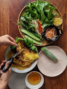 a person cutting food on top of a wooden table