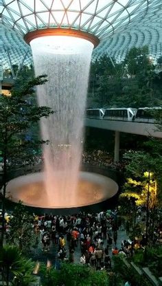 a large fountain in the middle of a mall filled with people