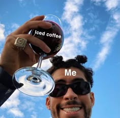 a man holding up a wine glass with the words iced coffee me