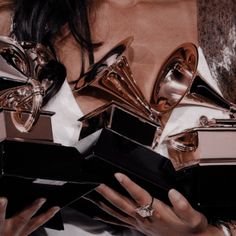 a woman holding several awards in her hands