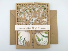 the wedding card is cut out from brown paper and has a tree with leaves on it