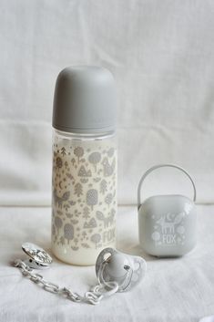 a baby bottle next to a chain and pacifier