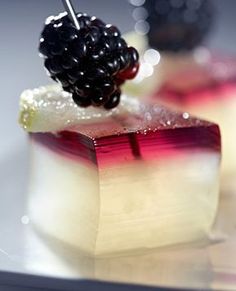 two desserts with blackberries and cream on them