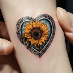 a heart shaped tattoo with a sunflower on it's side, in the shape of a heart