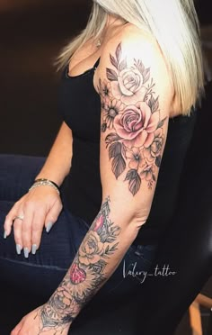 a woman sitting down with a flower tattoo on her arm