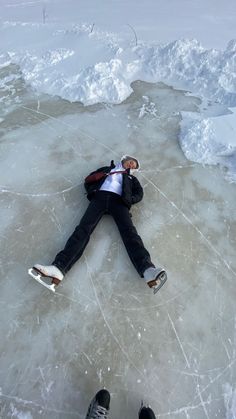 a man is laying on the ice with his feet in the air