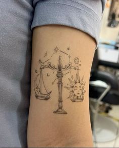 a lady with a tattoo on her arm that has an image of the scales of justice