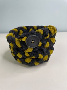 a black and yellow bracelet with a button on it