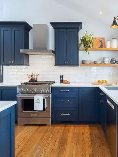 a kitchen with blue cabinets and wooden floors