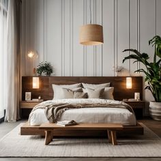 a large bed sitting next to a tall plant in a bedroom under a light fixture