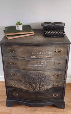 an old dresser with writing on it and a typewriter sitting on top of it