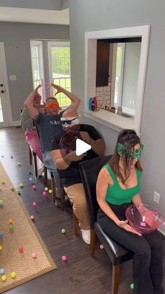 a group of people sitting on chairs in a room with confetti all over the floor