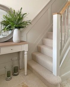 there is a plant on top of the table next to the stairs in this room