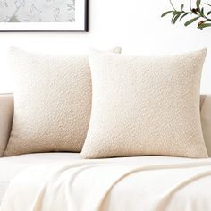 two white pillows sitting on top of a couch