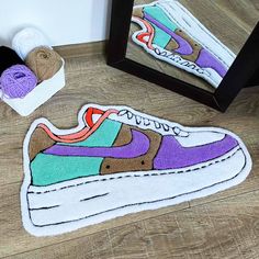 a pair of sneakers is sitting on the floor next to some yarn and a mirror