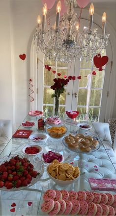 a table filled with lots of food on top of a glass table covered in cookies and pastries