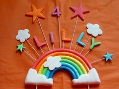 a rainbow cake with stars and clouds on it