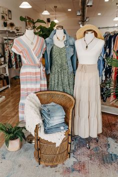 clothes are on display in a clothing store, with a wicker chair and basket