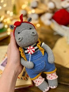 a crocheted stuffed hippo is being held up by someone's hand